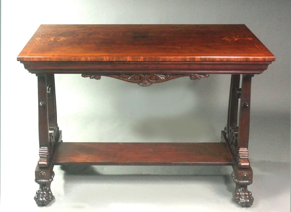A rectangular Regency mahogany centre table featuring corner inlay, carved scroll supports, a lower stretcher shelf, and carved lion paw feet. View II