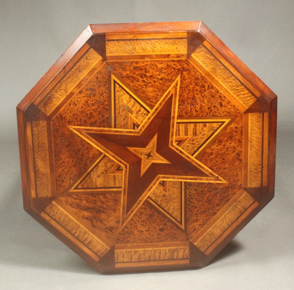 An octagonal side table featuring a central inlaid star pattern in contrasting timber veneers, set on turned legs with a cross-stretcher and castors. View II