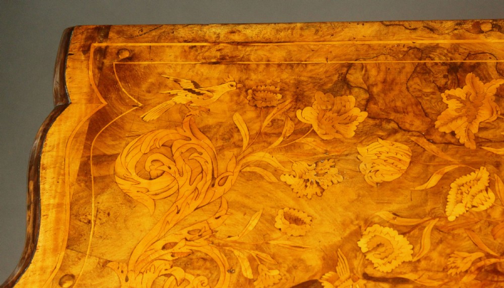 An antique Dutch walnut bombe chest featuring detailed floral marquetry inlays, four drawers, cast brass handles, and carved claw and ball feet. View VI
