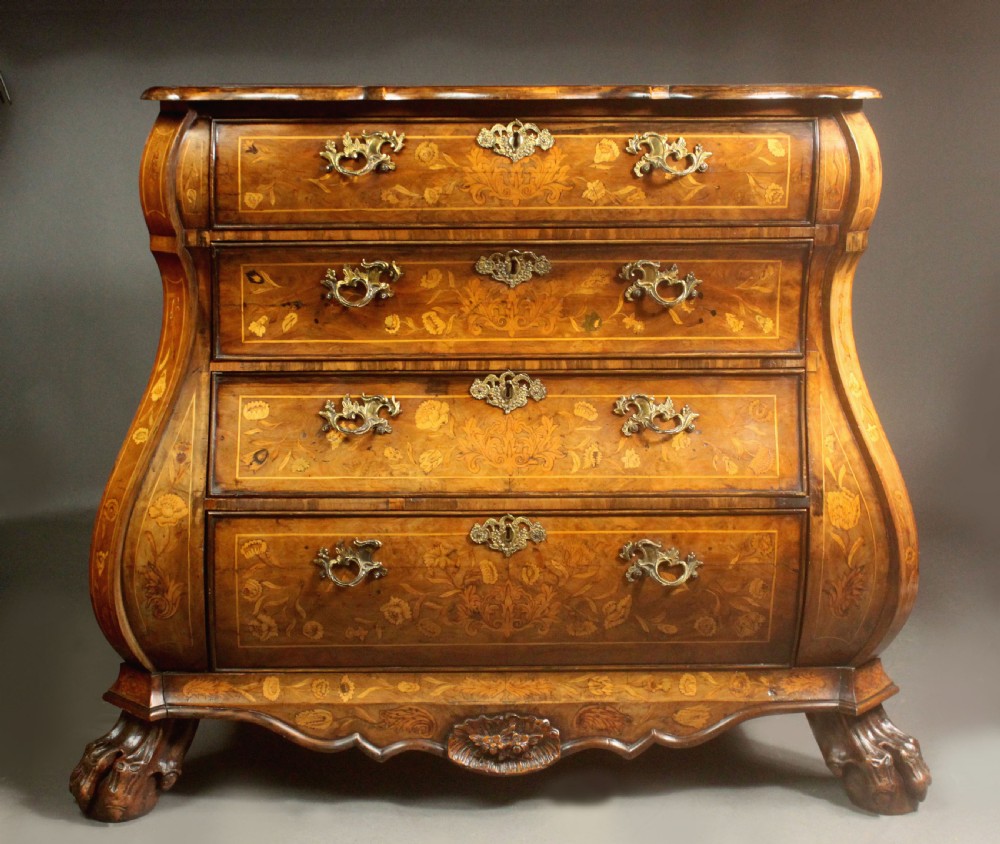 An antique Dutch walnut bombe chest featuring detailed floral marquetry inlays, four drawers, cast brass handles, and carved claw and ball feet. View VII
