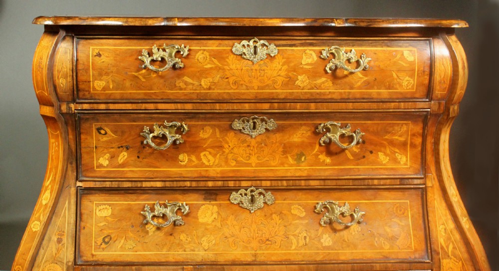 An antique Dutch walnut bombe chest featuring detailed floral marquetry inlays, four drawers, cast brass handles, and carved claw and ball feet. View IX