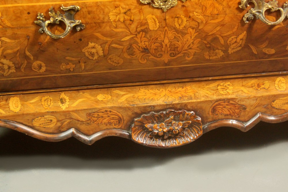 An antique Dutch walnut bombe chest featuring detailed floral marquetry inlays, four drawers, cast brass handles, and carved claw and ball feet. View X
