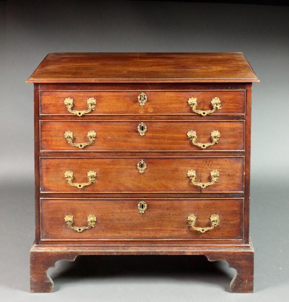 A Chippendale mahogany chest of drawers with four graduated drawers, brass rococo handles, keyhole escutcheons, and shaped bracket feet. View II