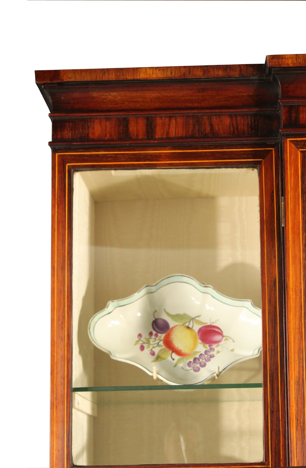 A Regency rosewood breakfront bookcase featuring four glazed upper doors and four lower doors lined with pleated fabric. View VI