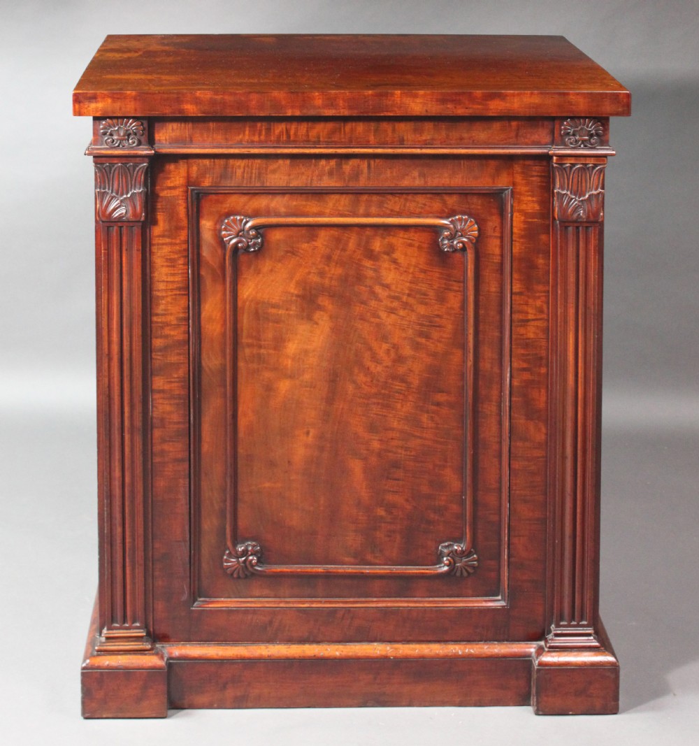 A nineteenth-century flame mahogany library cabinet featuring carved pilasters, reeded side columns, and a single recessed panel door set on a solid plinth base. View III