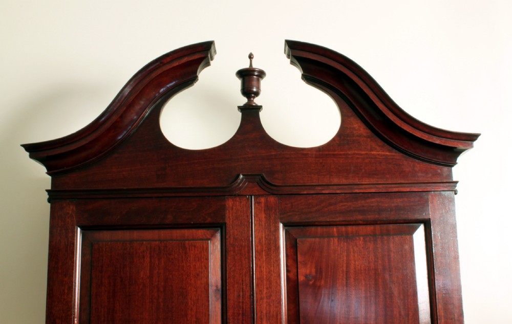 A Georgian mahogany bureau bookcase featuring a swan-neck pediment top, twin panelled upper doors, a slant-front writing bureau with fitted pigeonholes, and three base drawers on bracket feet. View VI