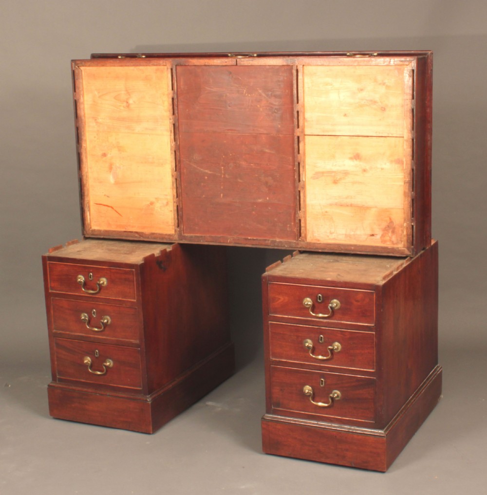 An antique Chippendale mahogany pedestal desk featuring nine cockbeaded drawers with brass swan-neck handles around a central kneehole, resting on twin plinth bases. View III