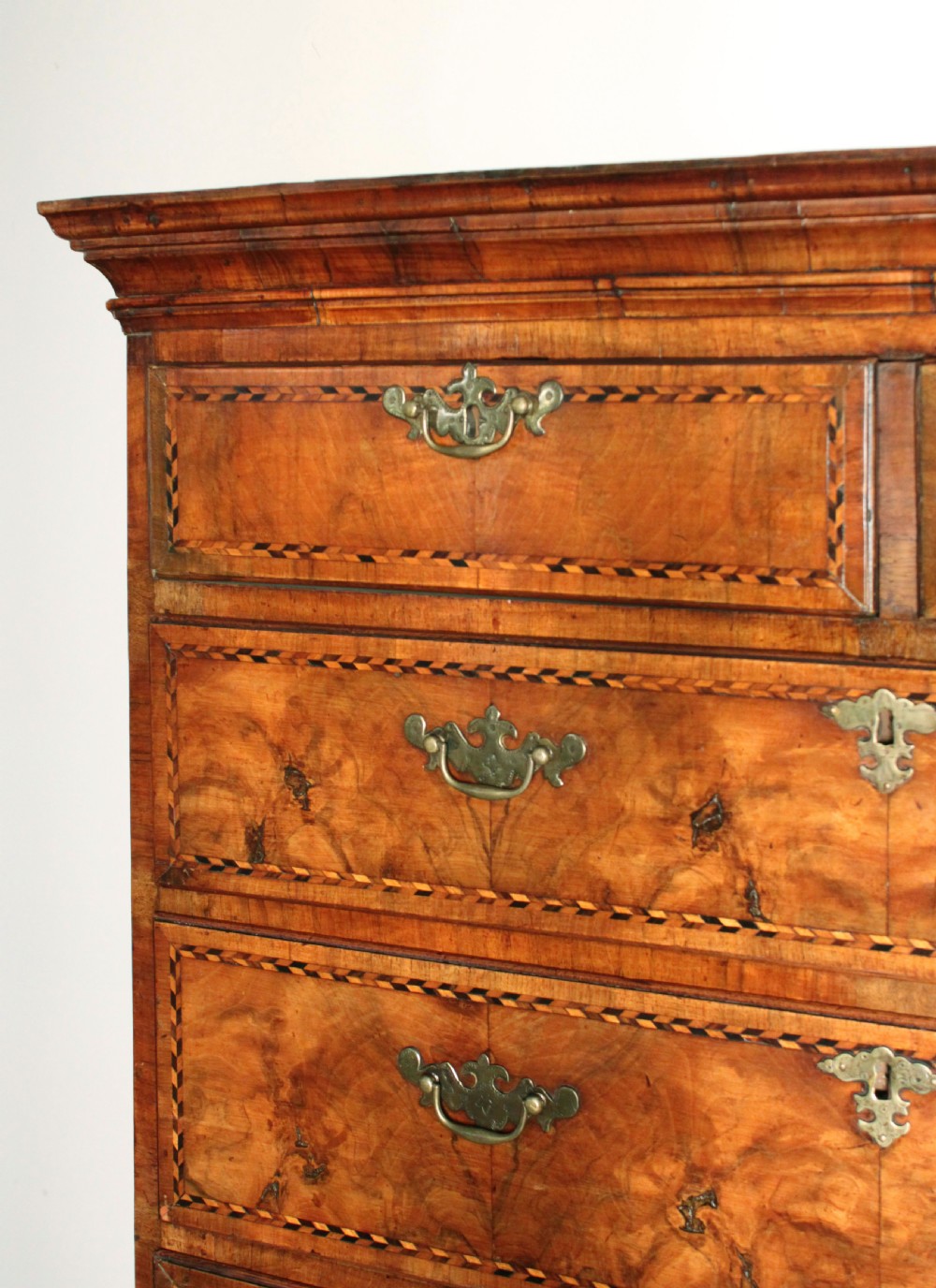 An eighteenth-century burr walnut tallboy chest-on-chest with feather-banded drawer fronts, brass handles, and bracket feet. View VI