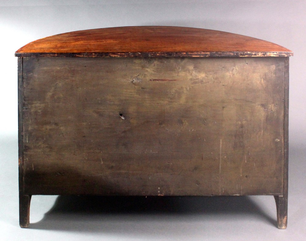 A late 18th-century George III flame mahogany demi-lune commode featuring four central drawers flanked by side cupboards, resting on bracket feet. View IV