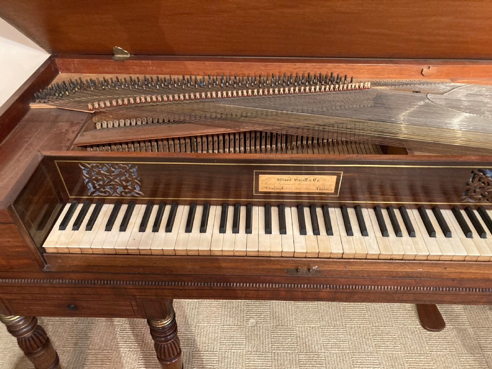 A Regency mahogany square piano crafted by Wood, Small and Co, raised on turned reeded legs with brass castors and featuring an open music rest. View IV