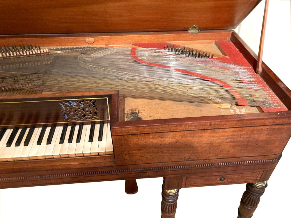 A Regency mahogany square piano crafted by Wood, Small and Co, raised on turned reeded legs with brass castors and featuring an open music rest. View V