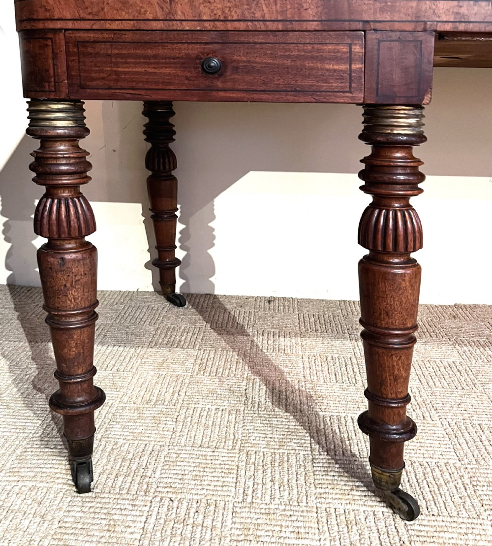 A Regency mahogany square piano crafted by Wood, Small and Co, raised on turned reeded legs with brass castors and featuring an open music rest. View VI