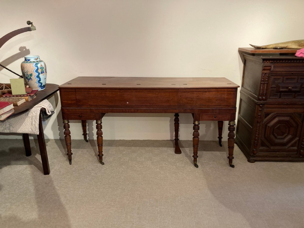 A Regency mahogany square piano crafted by Wood, Small and Co, raised on turned reeded legs with brass castors and featuring an open music rest. View IX