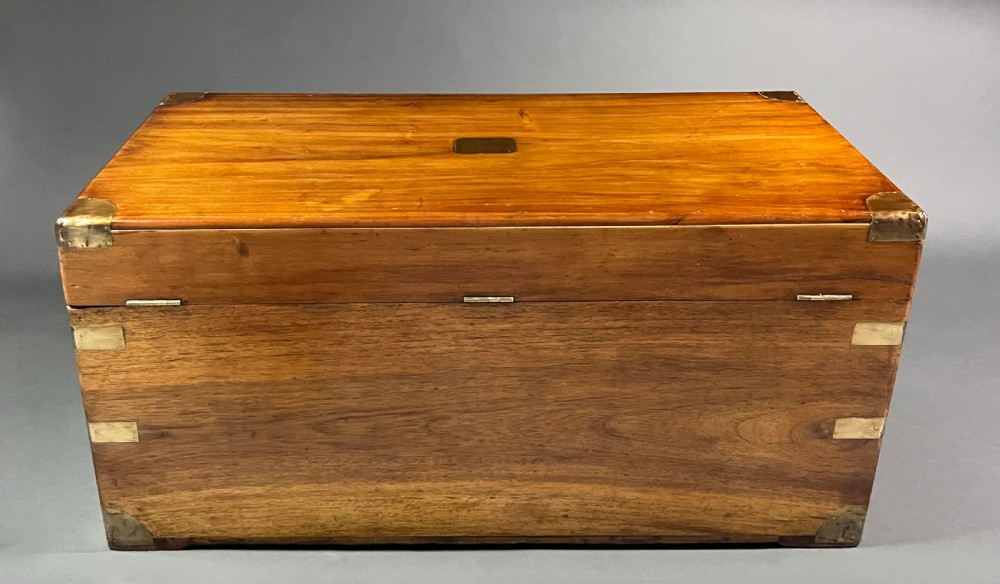An antique rectangular camphor wood campaign chest featuring recessed brass handles, corner brackets, and a central brass escutcheon. View IV