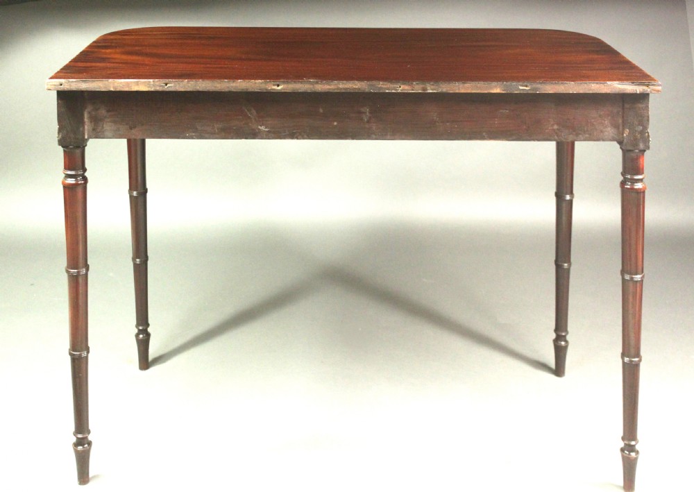 A matching pair of Georgian mahogany serving tables featuring flame veneer aprons and turned tapered legs. View V