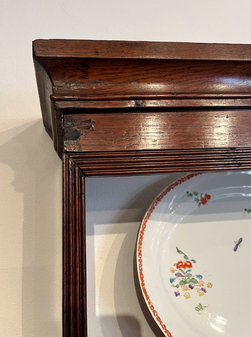 An antique oak dresser featuring a three-drawer base with brass swan-neck handles, topped with a tall open three-shelf plate rack. View V