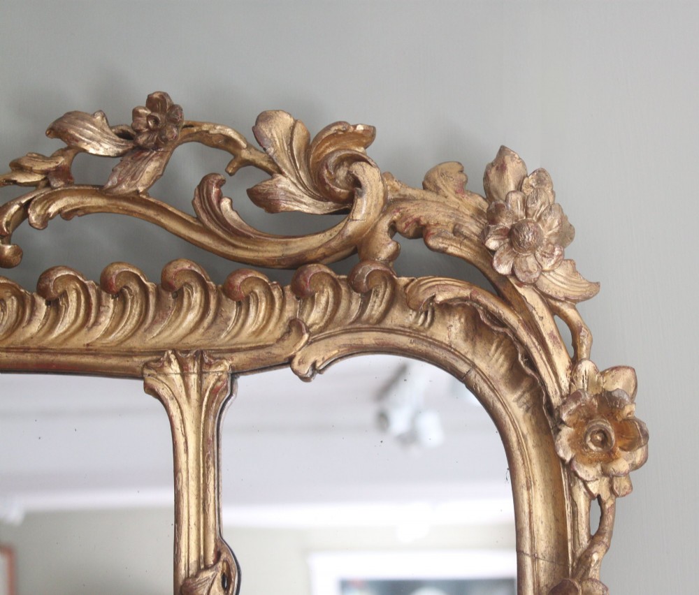 An ornate horizontal Chippendale giltwood overmantel mirror featuring intricate floral and leaf carvings around three glass panels. View III