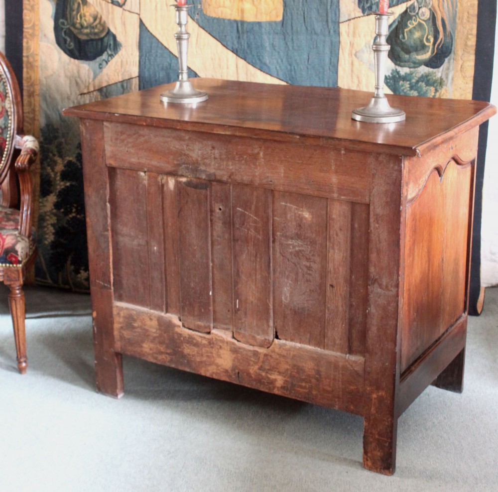 An 18th-century French Provincial walnut commode featuring three carved drawers with serpentine fronts and brass hardware. View V