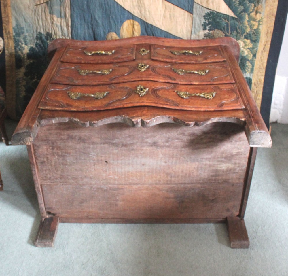 An 18th-century French Provincial walnut commode featuring three carved drawers with serpentine fronts and brass hardware. View VI