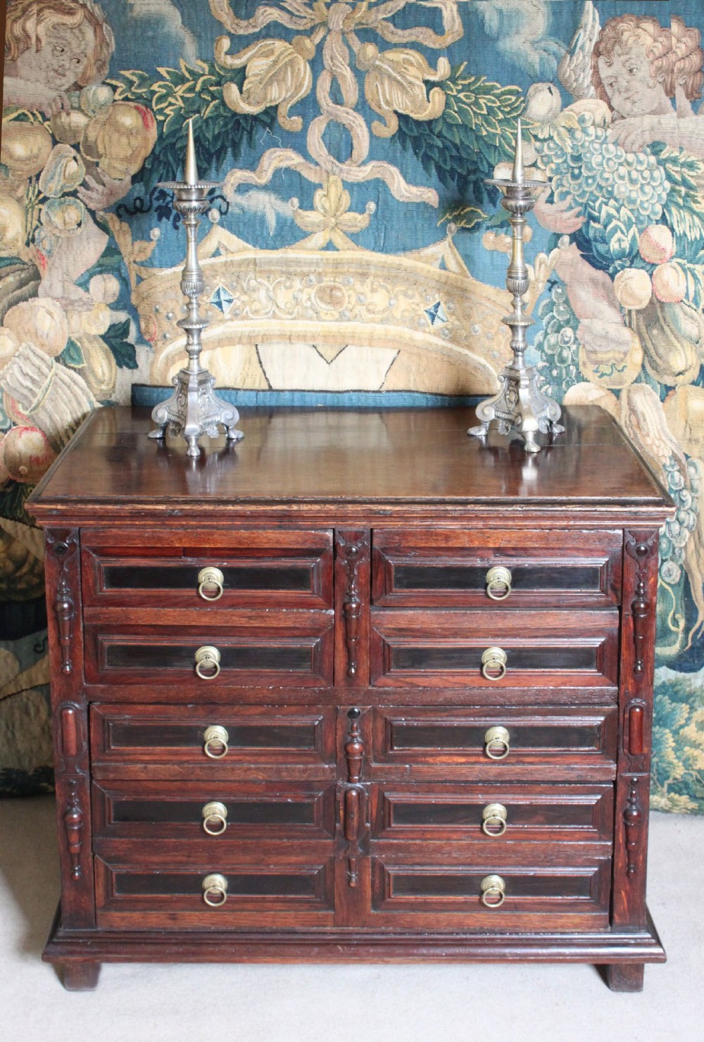 Dark brown Charles II oak chest of drawers featuring geometric moulded drawer fronts and brass drop handles. View VIII