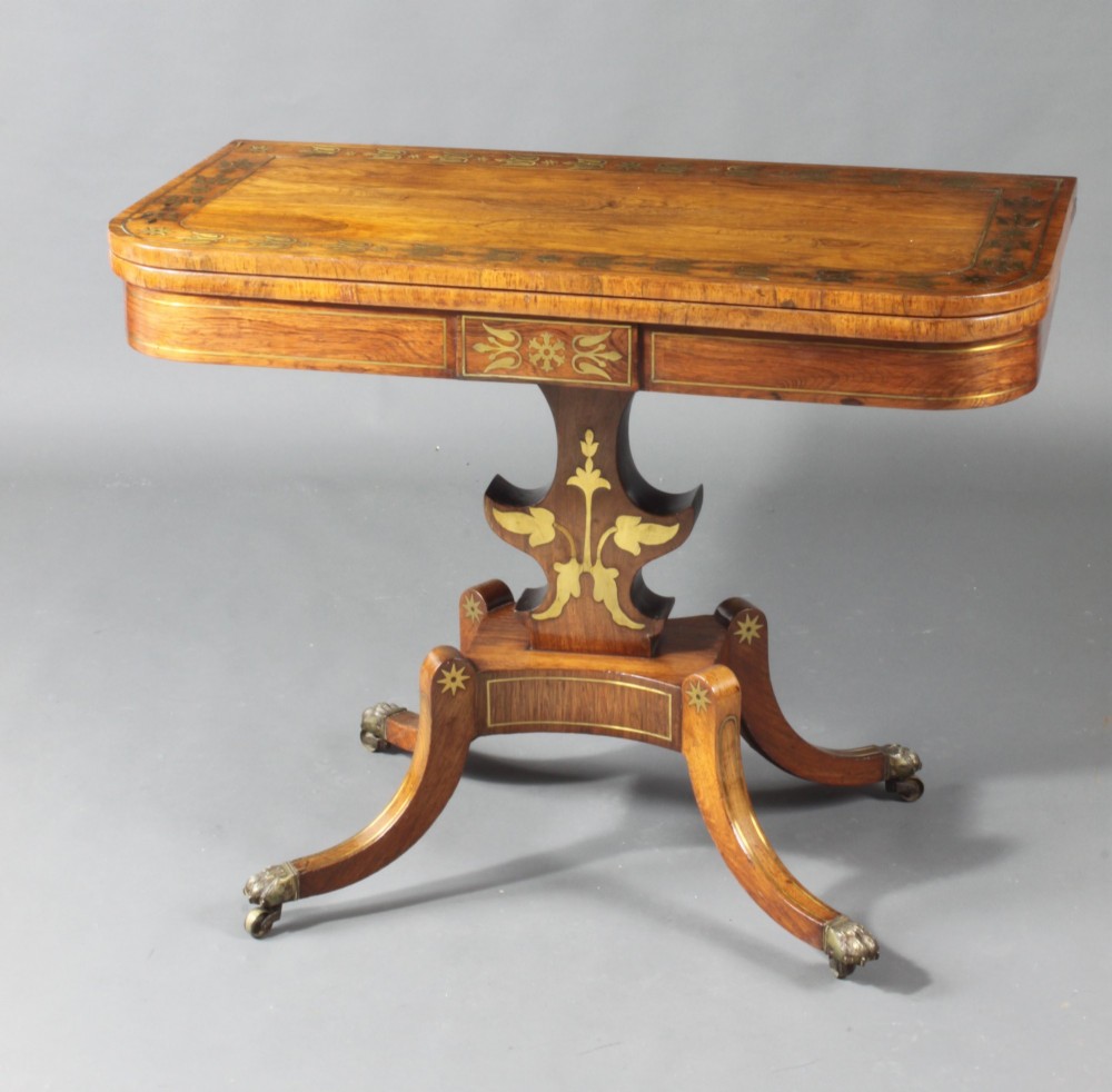 A pair of Regency rosewood card tables featuring brass foliate inlay, fold-over tops, pedestal bases, and splayed legs with brass paw castors. View II