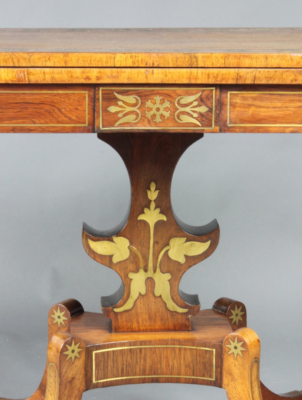 A pair of Regency rosewood card tables featuring brass foliate inlay, fold-over tops, pedestal bases, and splayed legs with brass paw castors. View III