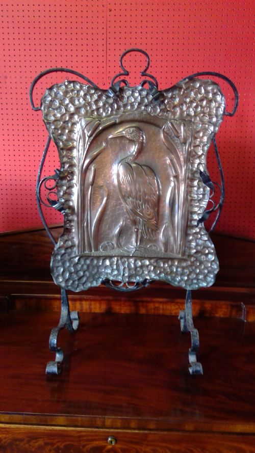 john pearson newlyn school of arts .attr.,an arts and crafts finely embossed and planished copper  fire guard screen,enclosed within a  wrought hand forged ironworked frame