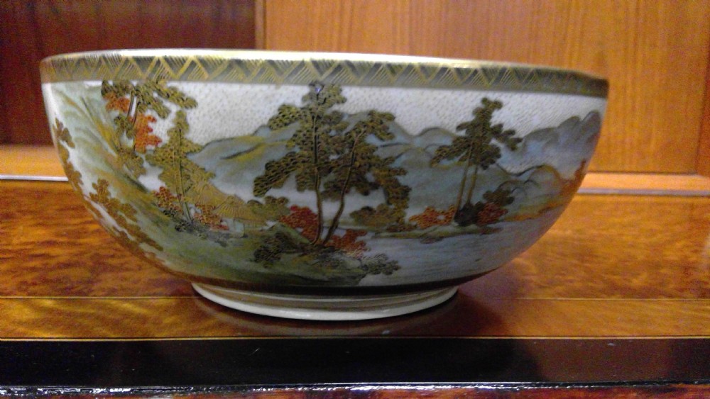 A circular Japanese Satsuma ceramic bowl featuring a hand-painted interior landscape with pagodas, trees, mountains, and gilt accents. View VII