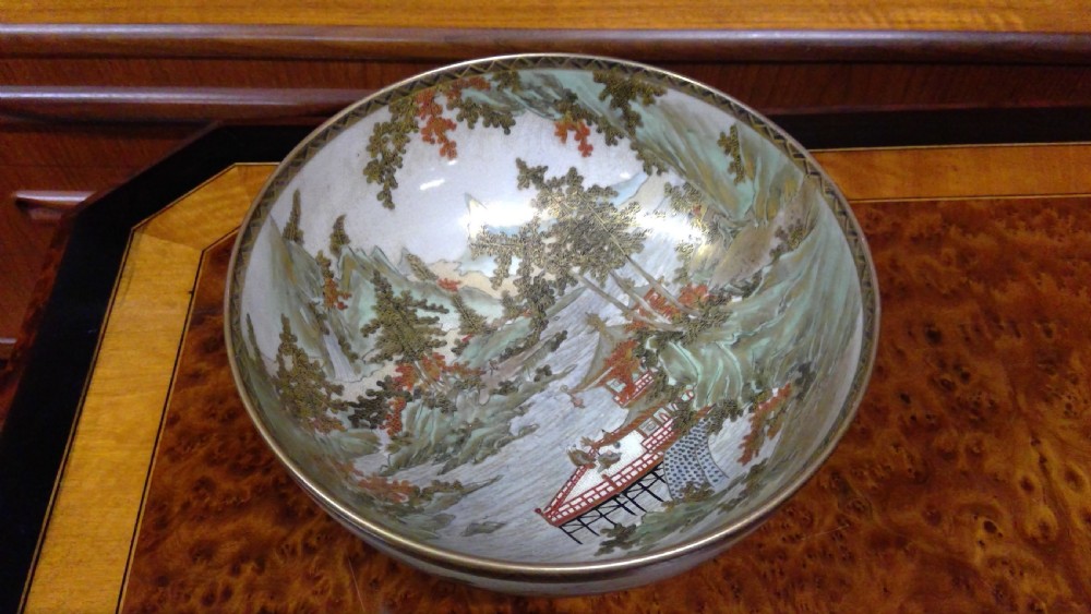 A circular Japanese Satsuma ceramic bowl featuring a hand-painted interior landscape with pagodas, trees, mountains, and gilt accents. View XIV
