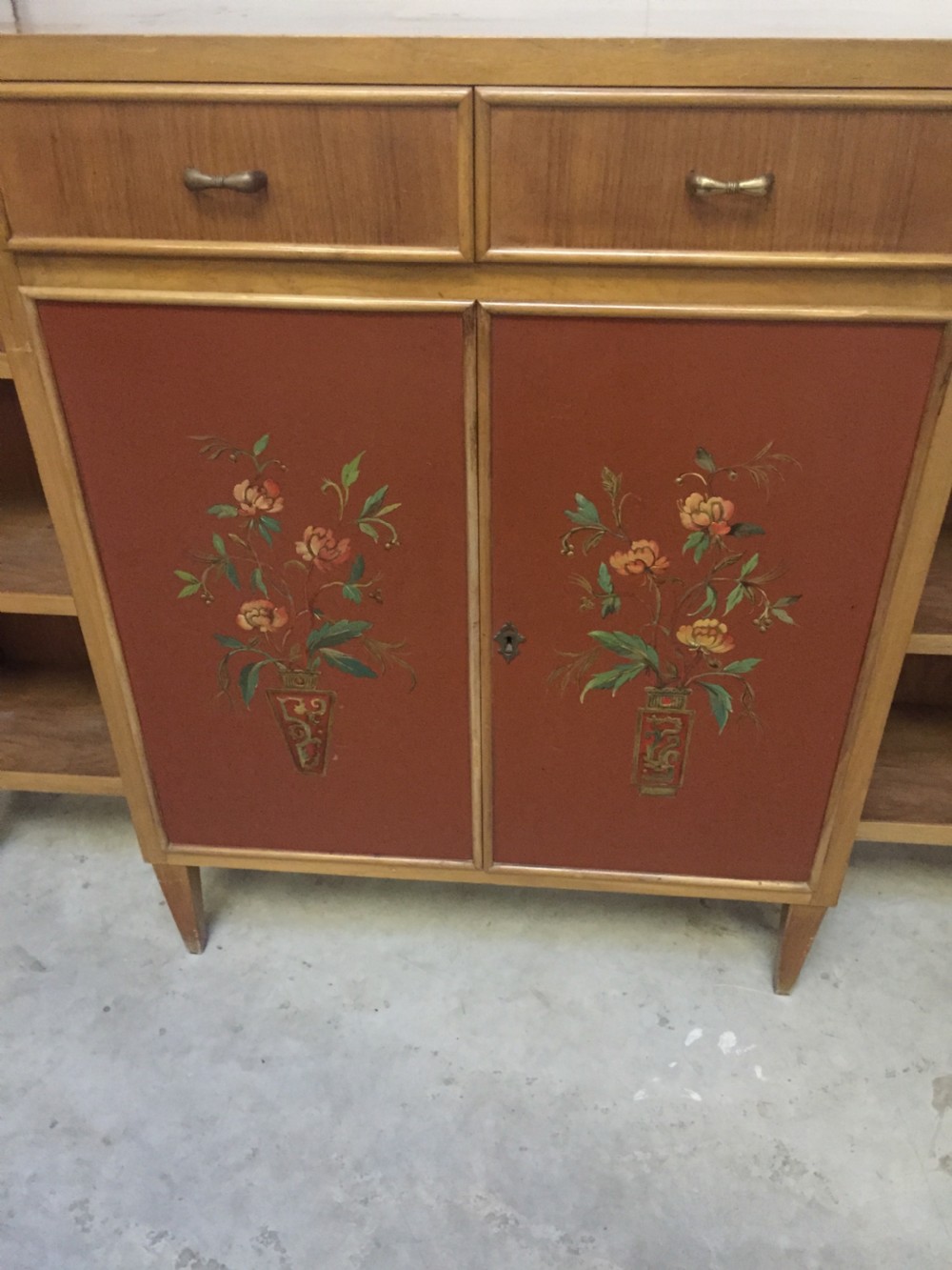 A matching pair of low mid-century breakfront bookcases in light wood with hand-painted red central doors and open side shelving. View III