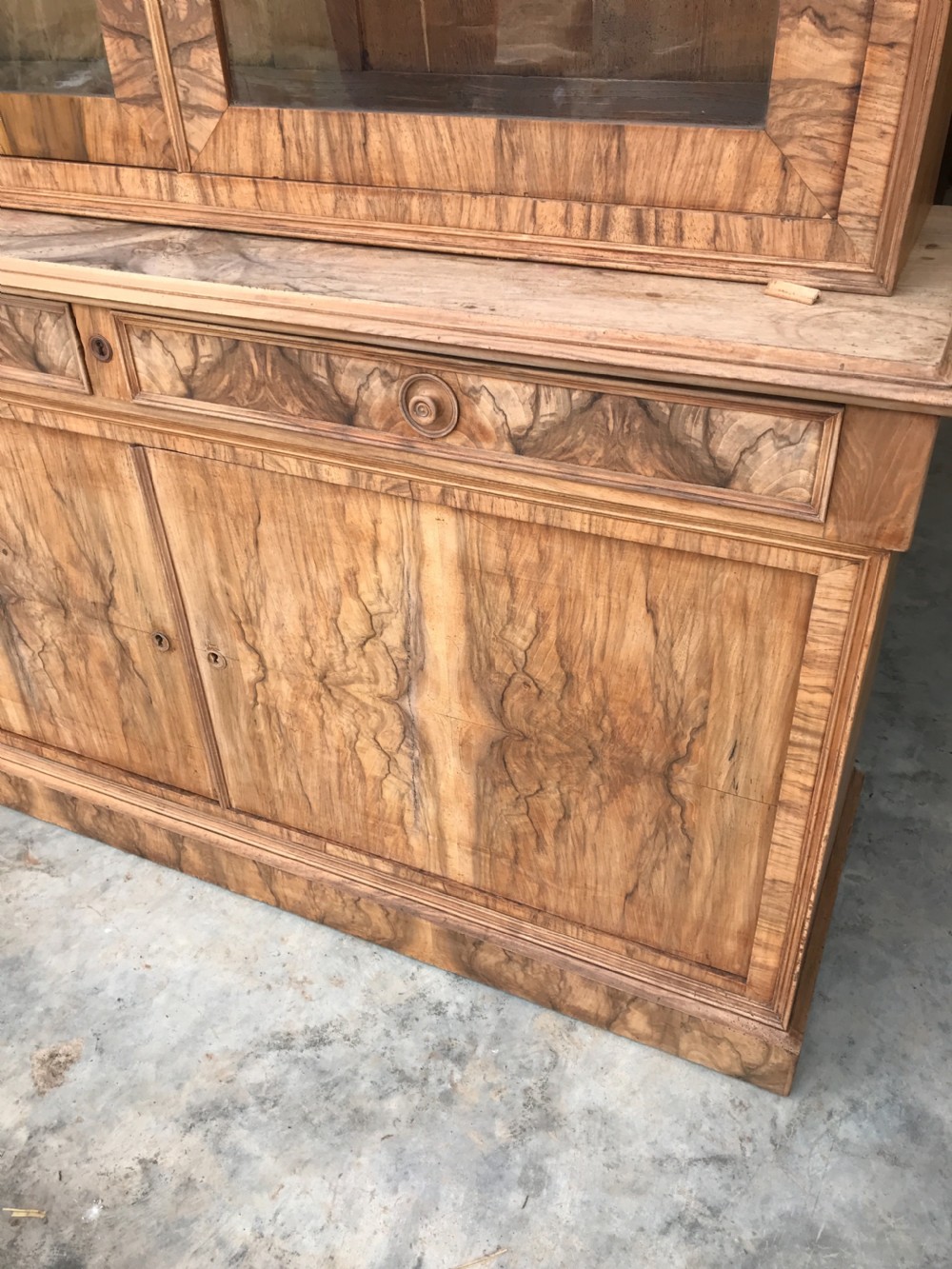A tall 19th-century figured walnut glazed bookcase featuring double glass doors above two frieze drawers and a double-door lower cupboard base. View II