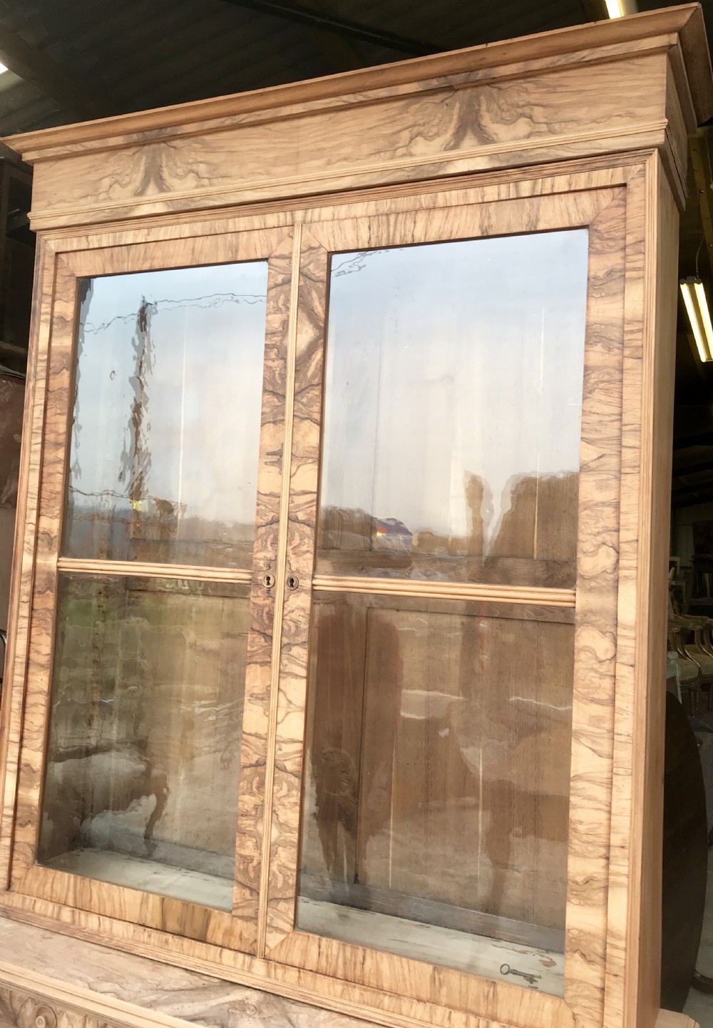 A tall 19th-century figured walnut glazed bookcase featuring double glass doors above two frieze drawers and a double-door lower cupboard base. View III