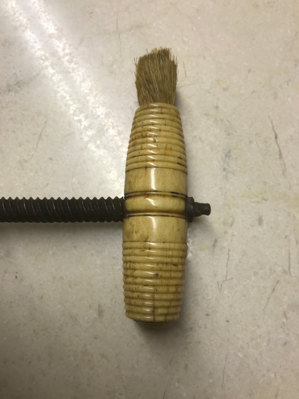 An antique Victorian mechanical brass corkscrew with a ribbed turned bone handle, an integrated dusting brush, and a steel helix worm at the base. View II