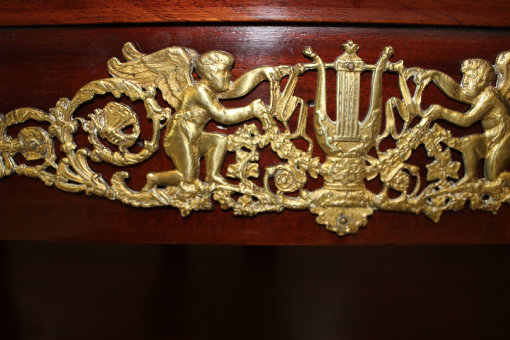 A pair of dark mahogany French Empire console tables featuring green marble tops, winged eagle supports, lower plinth shelves, and ornate gilt bronze mounts. View VIII