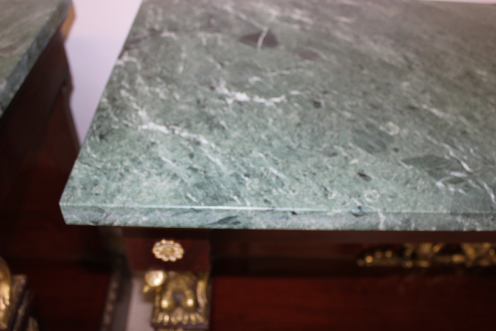 A pair of dark mahogany French Empire console tables featuring green marble tops, winged eagle supports, lower plinth shelves, and ornate gilt bronze mounts. View X