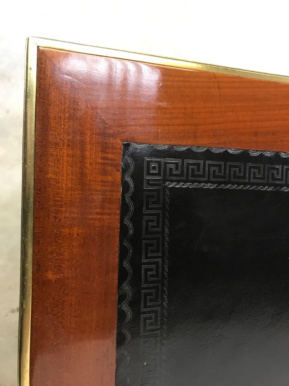 An antique mahogany pedestal desk featuring a dark leather writing top, multiple drawers with brass keyhole escutcheons, and central metal mounts. View VI