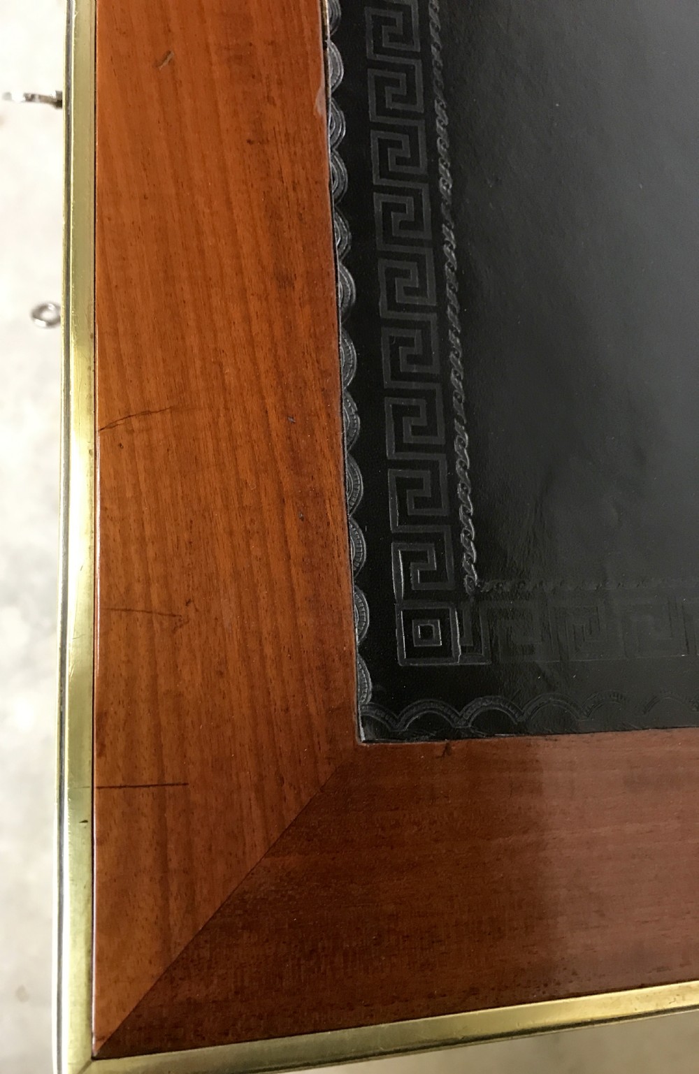 An antique mahogany pedestal desk featuring a dark leather writing top, multiple drawers with brass keyhole escutcheons, and central metal mounts. View VII