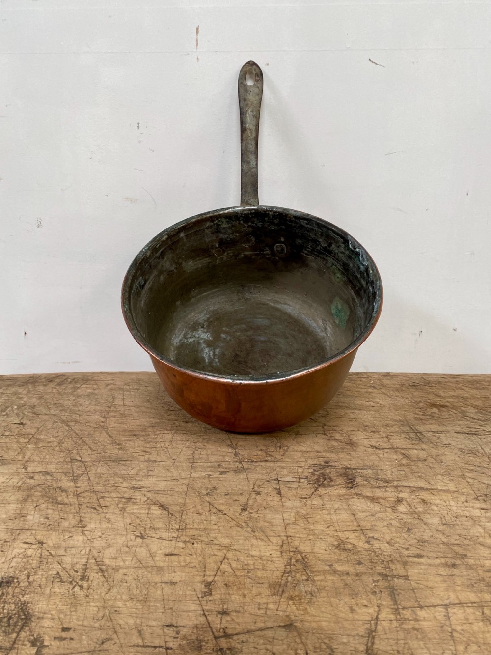 A 19th-century copper saucepan with a polished copper body, rolled rim, and a curved dark iron handle riveted to the side. View III