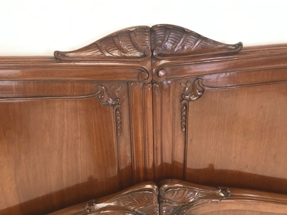A carved mahogany king size bed frame featuring an arched headboard and matching footboard with intricate foliate detailing and cabriole feet. View III