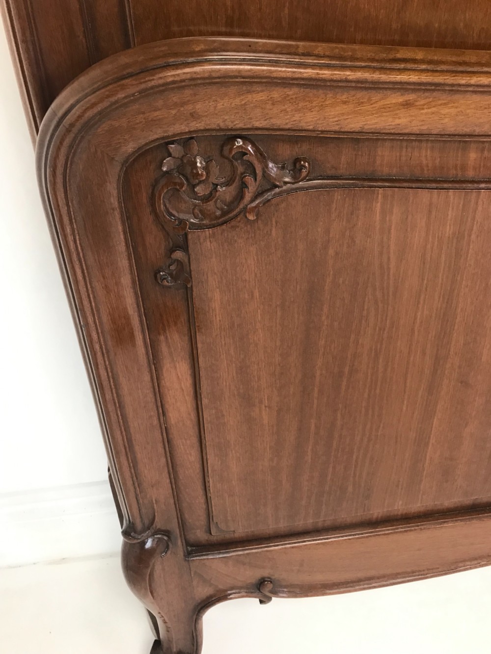 A carved mahogany king size bed frame featuring an arched headboard and matching footboard with intricate foliate detailing and cabriole feet. View IV