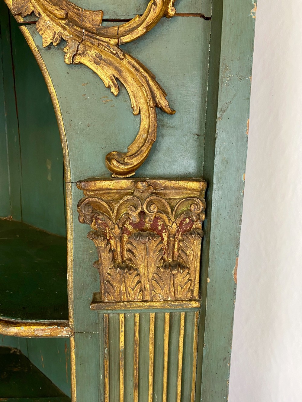 An 18th-century floor-standing teal green open corner cupboard featuring gold leaf detailing, fluted pilasters, and a broken swan-neck pediment. View IV