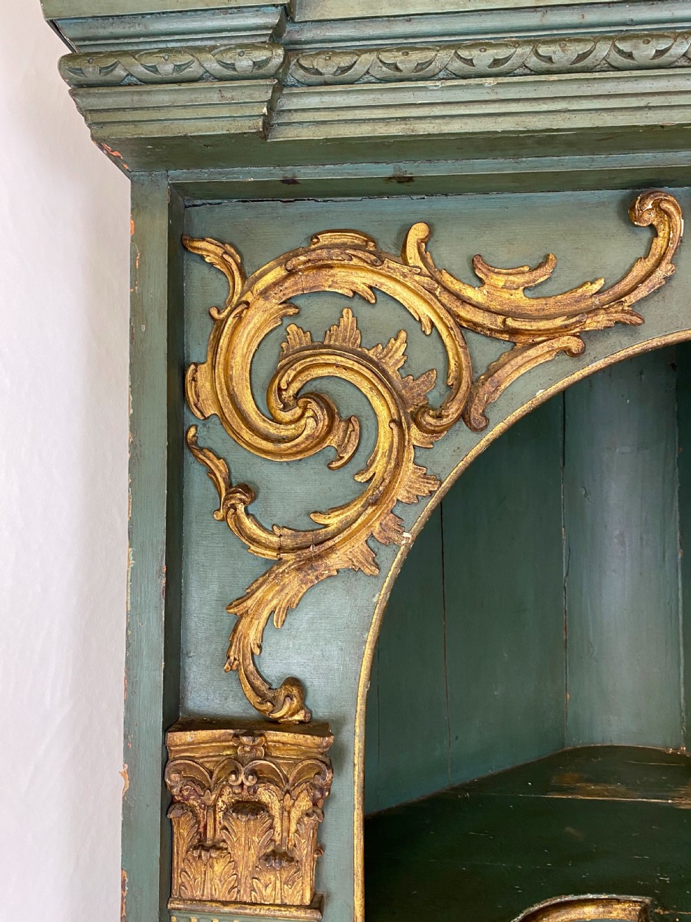 An 18th-century floor-standing teal green open corner cupboard featuring gold leaf detailing, fluted pilasters, and a broken swan-neck pediment. View VI