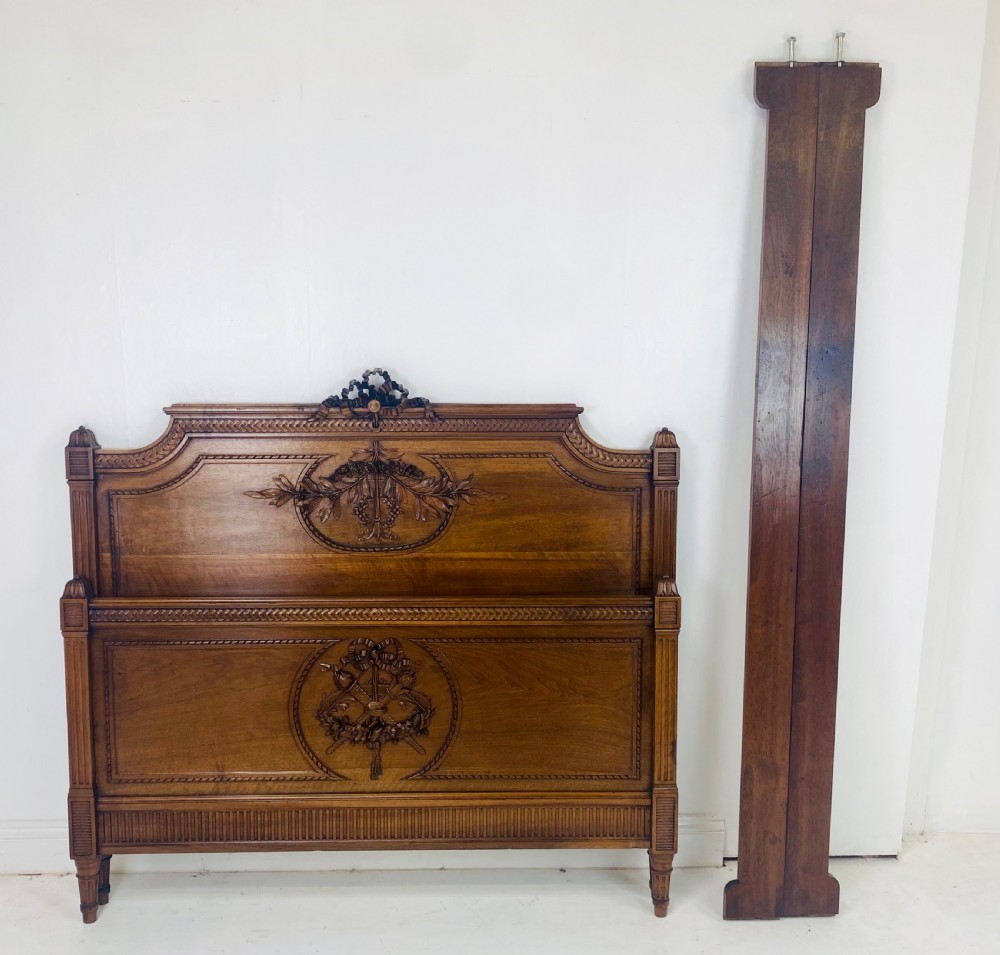 Carved walnut wood bed headboard and footboard set featuring classical ribbon and swag relief details. View III
