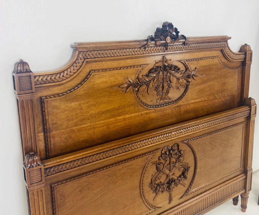 Carved walnut wood bed headboard and footboard set featuring classical ribbon and swag relief details. View V