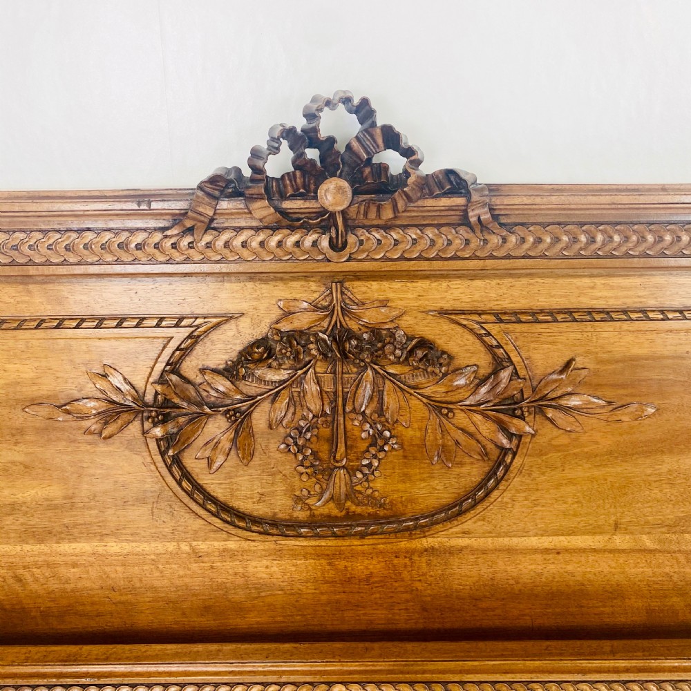 Carved walnut wood bed headboard and footboard set featuring classical ribbon and swag relief details. View VII
