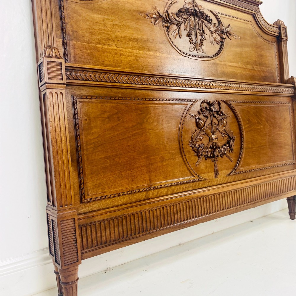 Carved walnut wood bed headboard and footboard set featuring classical ribbon and swag relief details. View VIII