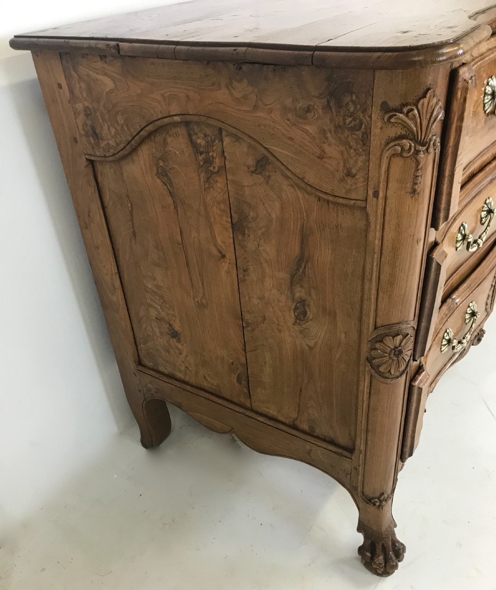 An 18th-century French provincial burr ash commode featuring three drawers with carved rocaille motifs, original brass handles, and cabriole legs. View III
