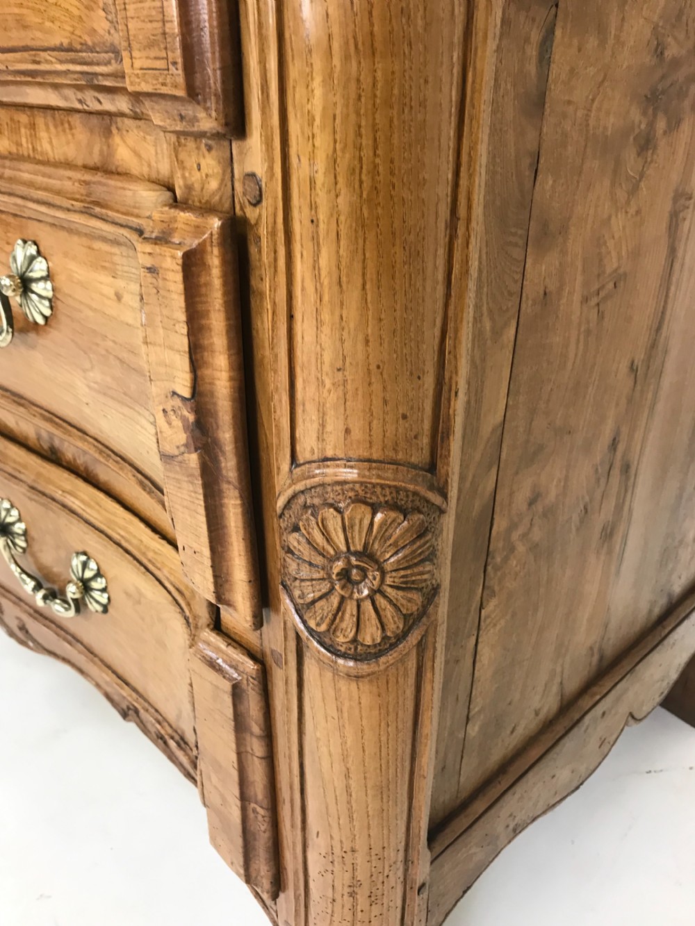 An 18th-century French provincial burr ash commode featuring three drawers with carved rocaille motifs, original brass handles, and cabriole legs. View VII