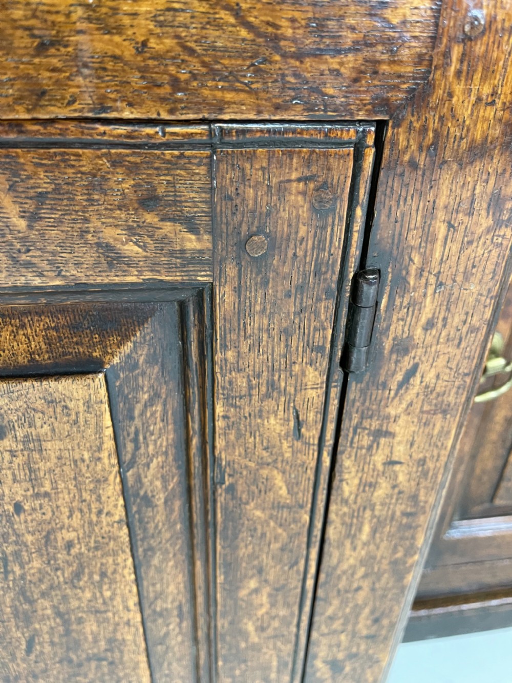 A large dark oak dresser featuring a multi-tiered open plate rack top above a wide base with drawers and panelled cupboard doors. View XII