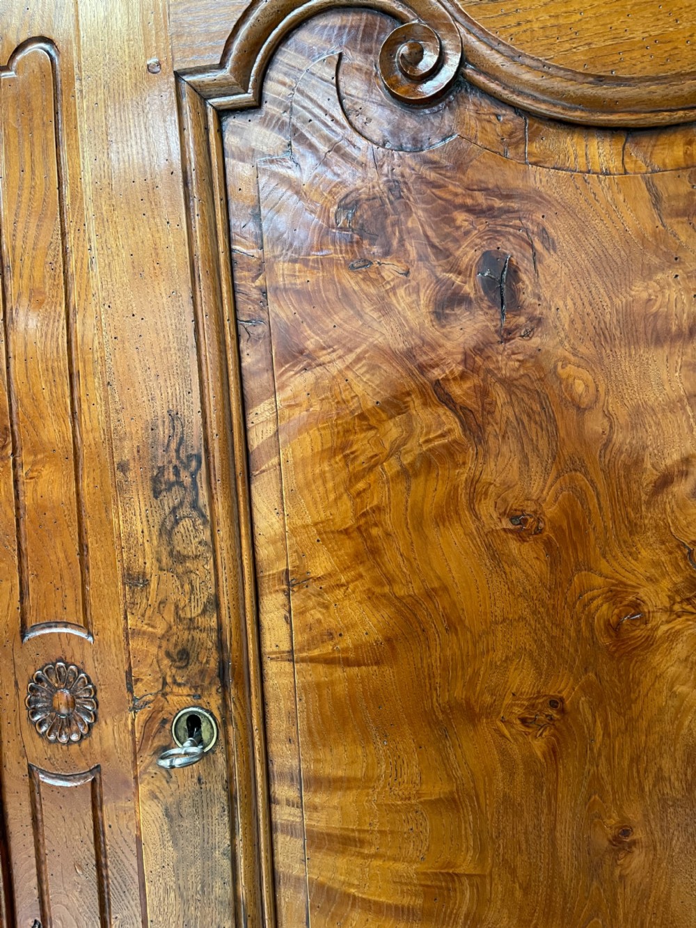 An antique two-piece French walnut cabinet featuring carved floral crests, molded panel doors, two drawers, and short cabriole feet. View V